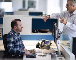 Image de deux personnes dans un bureau en train de converser.
