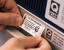 Image of a personal applying a U.S. Field Evaluation sticker to an appliance.