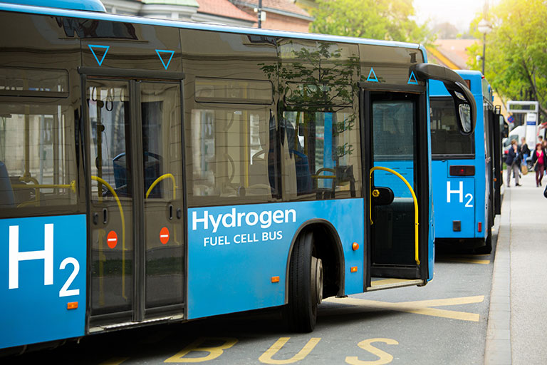 A hydrogen fuel cell-powered bus stands at the station